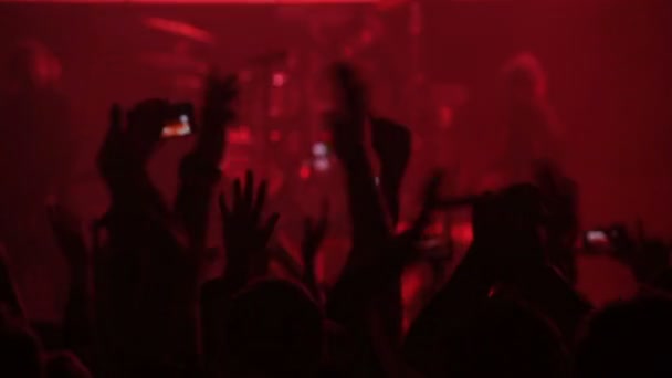 En man som sjunger på en konsert, folk vifta med händerna och skjuta på telefonen — Stockvideo