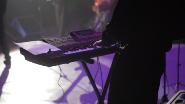 Um homem no palco está a tocar um sintetizador, um concerto. — Vídeo de Stock