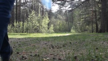 Bir adam ormanda yürür ve çöp, çöp plastik bir şişe atar