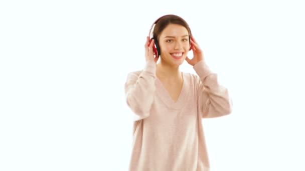 Chica escuchando música con auriculares inalámbricos y bailando, aislada — Vídeos de Stock