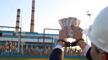 Bir erkekte sayıları para dolar enerji santrali arka plan, günbatımı, yakın çekim karşı kelepçe