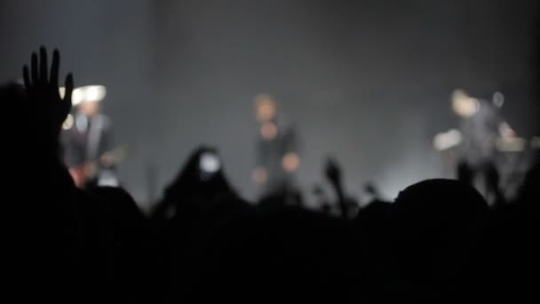 La cantante está actuando en el escenario, la gente está agitando sus manos, borrosa — Vídeos de Stock