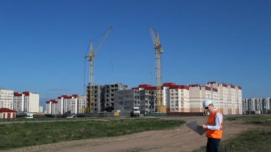 Siyah gözlük ve beyaz kask denetçisinde bir konut ev inşaatı denetler