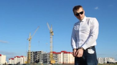 Para dolar inşaat arka planı ile kelepçeli Başmüfettiş siyah gözlük standları