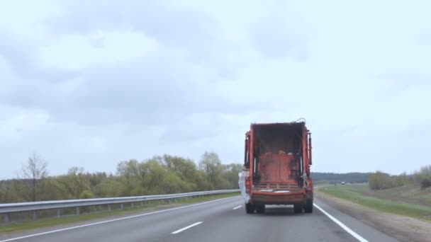 O caminhão do lixo está se movendo ao longo da estrada, o carro que carrega lixo está dirigindo ao longo da estrada — Vídeo de Stock