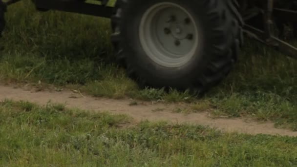 Старий трактор косить траву на полі — стокове відео