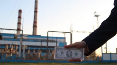 Para dolar bir elektrik santrali arka plan ile bir eldir kelepçeli, yakın çekim, günbatımı, rüşvet, tutuklama