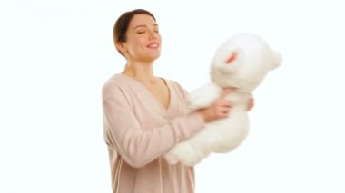 Genç kadın beyaz bir oyuncak ayı izole kırmızı taşlarla sarılma