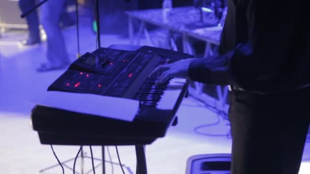 Ein Mann auf der Bühne spielt einen Synthesizer, ein Konzert — Stockvideo