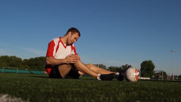 プレイヤーはサッカーの試合中に怪我を支えてきた — ストック動画