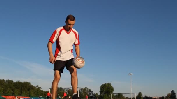 Jugador de fútbol está entrenando y rebotando una pelota de fútbol por su pie — Vídeos de Stock