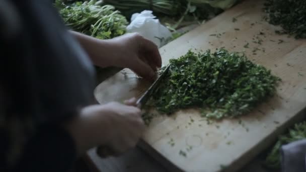 Frau schneidet Grünzeug auf Kreidetafel, Nahaufnahme — Stockvideo
