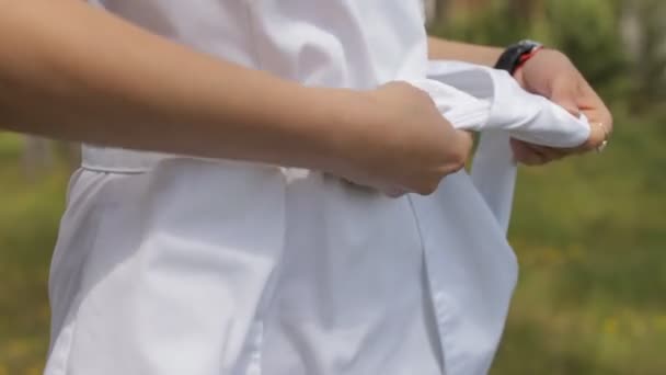 Mädchen binden ein Kleid, Fliege, in der Natur, Nahaufnahme — Stockvideo