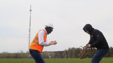 İki adam bir ip ile bir telefon Kulesi, bir casus, hırsızlık, iki kişi, bir işçi ve bir patron arka planda çalmaya hazırlanıyor