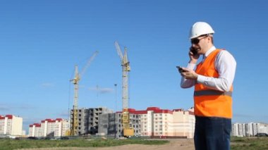 Şef Müfettiş üzerinde bir ev inşa arka planı iki telefon konuşuyor