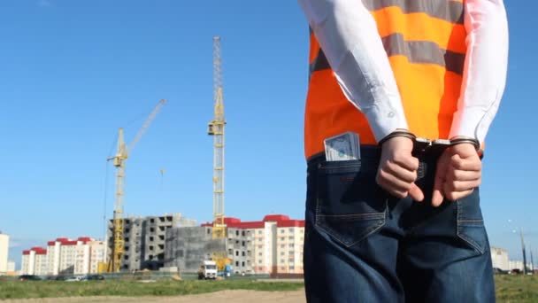 Ingenieur-Inspektor wird vor dem Hintergrund des Baus eines Wohnhauses mit Geld gefesselt