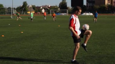 Eğitim ve bir futbol topu ayağı ile sıçrayan futbol oyuncusu