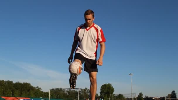 Ποδοσφαιριστής κλωτσάει την μπάλα με τα πόδια του στο ποδόσφαιρο πρακτική — Αρχείο Βίντεο