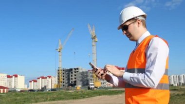 Baş Denetçisi'nde siyah gözlük sakız ve telefonda bir ev inşa arka plan üzerinde tırmanma, mühendis inşaat site arka plan üzerinde telefon aracılığıyla arıyor