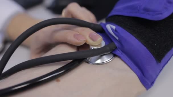 Um médico mede a pressão sobre um homem, close-up — Vídeo de Stock