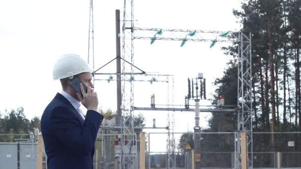 Šéf předá pracovníkovi na pozadí elektrárny — Stock video