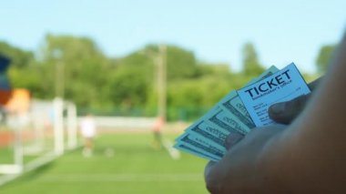Bir adam o futbol, spor bahisleri, yakın çekimler oynar Stadyumu zemine karşı kazandığı parayı düşünüyor
