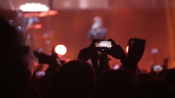 Een man op het concert neemt foto's van de zanger — Stockvideo