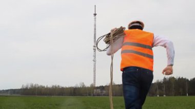 Bir ip siyah maskeli bir adam bir telefon Kulesi, arka planı özelliği çalmak kaçıyor