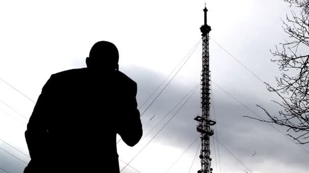 Muž mluvil po telefonu v pozadí telefonní věž, kontrola mobilní sítě — Stock video
