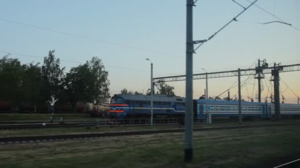 Вид из окна поезда, пассажирский дизельный поезд стоит на станции — стоковое видео