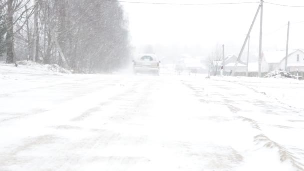 他的车骑在雪路上, 冬天和强烈的暴风雪 — 图库视频影像