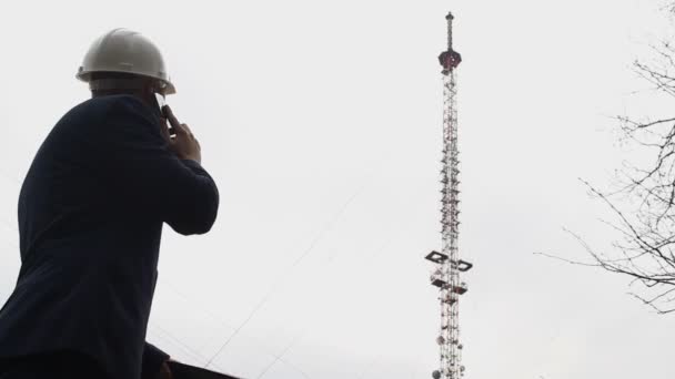 Den onda chefen pratar i telefon och skakar mappen på bakgrunden av Telefontornet, uttrycker missnöje — Stockvideo