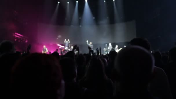 El público en el concierto agitando sus manos, en el escenario un espectáculo de luz, un concierto — Vídeos de Stock