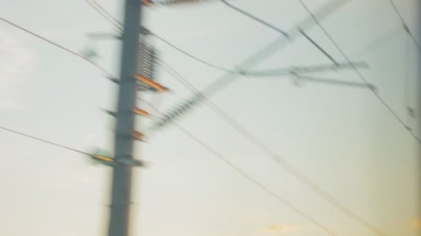 Vista desde la ventana del tren, cables de alto voltaje en los postes — Vídeo de stock