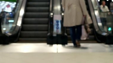 İnsanlar tırmanmaya ve binmek bir yürüyen merdiven bulanık, bir alışveriş merkezi içinde hareketli merdiven