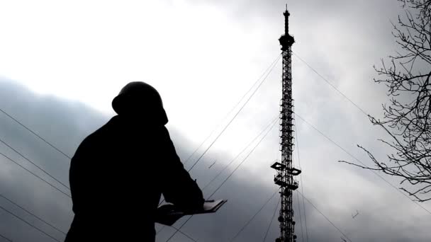 Inspector, el trabajador escribe mal funcionamiento en una carpeta y mira una torre de televisión — Vídeo de stock