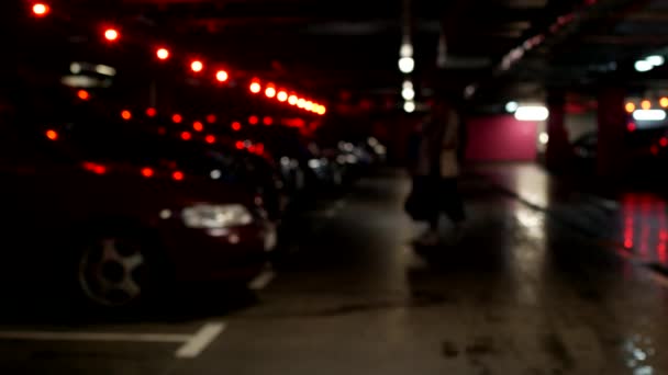 Две женщины идут и садятся в свой автомобиль на подземной парковке, размытый — стоковое видео