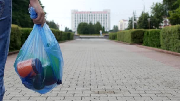 Un joven tira un paquete de basura en el centro de la ciudad, la hojarasca — Vídeos de Stock