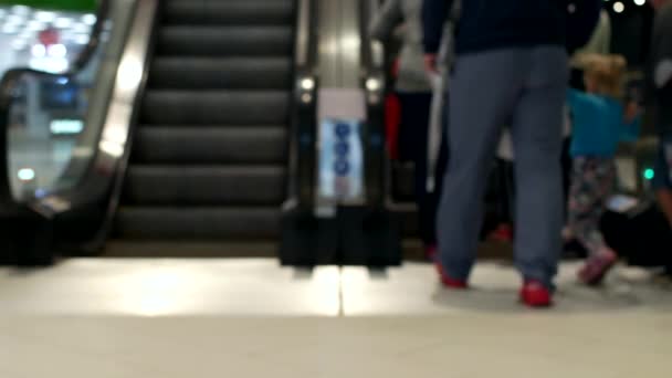 Uma multidão de pessoas se levantar e andar em uma escada rolante no aeroporto, borrado, fundo — Vídeo de Stock