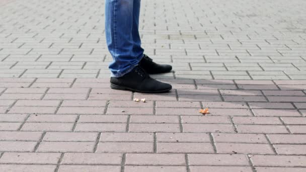 Een man in de stad is het gooien van uit zijn zak papieren uit snoep, close-ups — Stockvideo