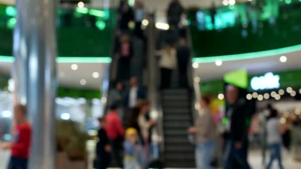 Una multitud de personas se levantan y montan en una escalera mecánica en el aeropuerto, borrosa, fondo — Vídeos de Stock