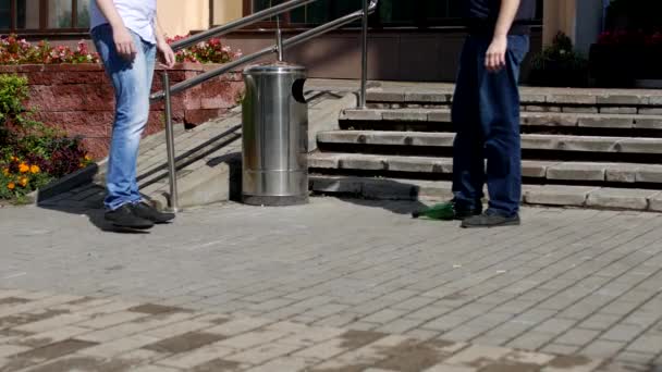 Twee mannen voetballen met een plastic fles in de buurt van de Prullenbak, close-up, vervuiling van de stad met huisvuil — Stockvideo