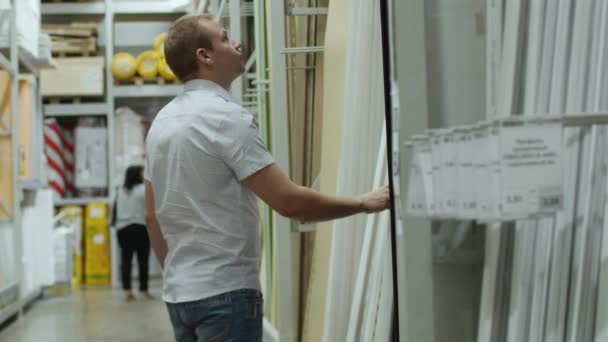 Pembeli laki-laki memilih laminasi di toko bahan bangunan — Stok Video