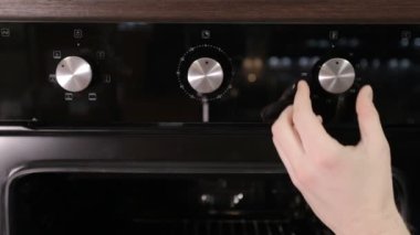 Bir erkek sıcaklık twist bir modern gaz sobası, yakın çekim, modern Ocak kolu out koyar