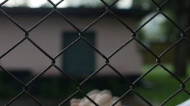 Metal ızgara arkasındaki adam orta parmak kadar yakın çekim, olumsuzluk, ağır çekim bir jestle gösterir