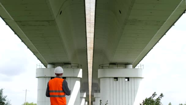 Inspektör ingenjör kontrollerar villkora av motor bron över floden — Stockvideo