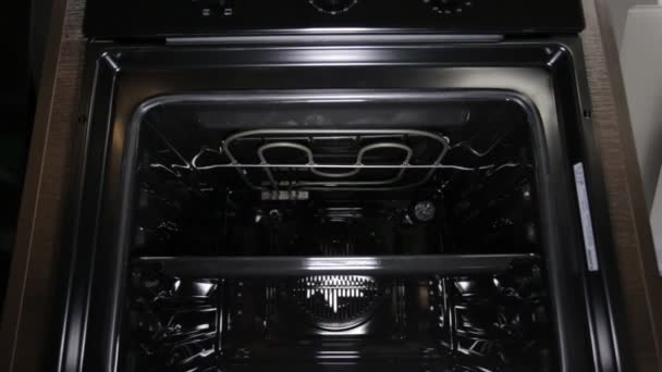 Black stylish and modern gas stove with convection, close-up, view inside, grill — Stock Video