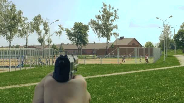 Pistolet dans les mains vise les enfants sur l'aire de jeux, les enfants à risque, vue à la première personne — Video