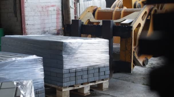 Loader machine loads finished interlocking concrete pavers — Stock Video