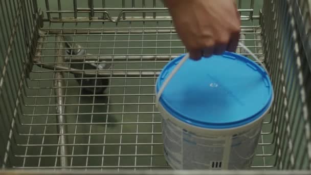 Käufer legt eine Dose Farbe, Walze und Pinsel in den Einkaufswagen — Stockvideo